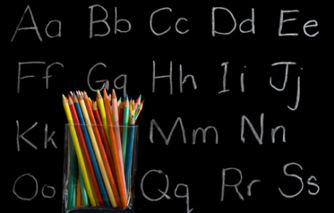 английский алфафит на школьной доске мелом - цветные карандаши в стакане на столе